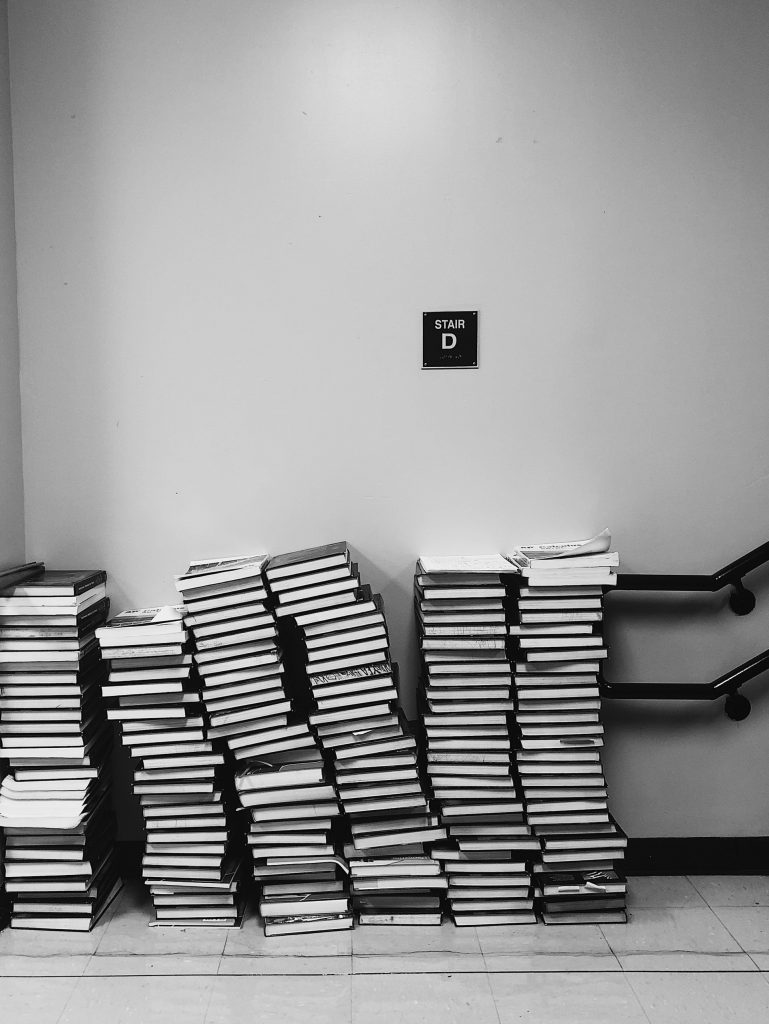 Six tall stacks of text books on floor